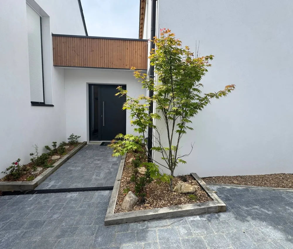 entrée de maison moderne avec porte noire et jardin