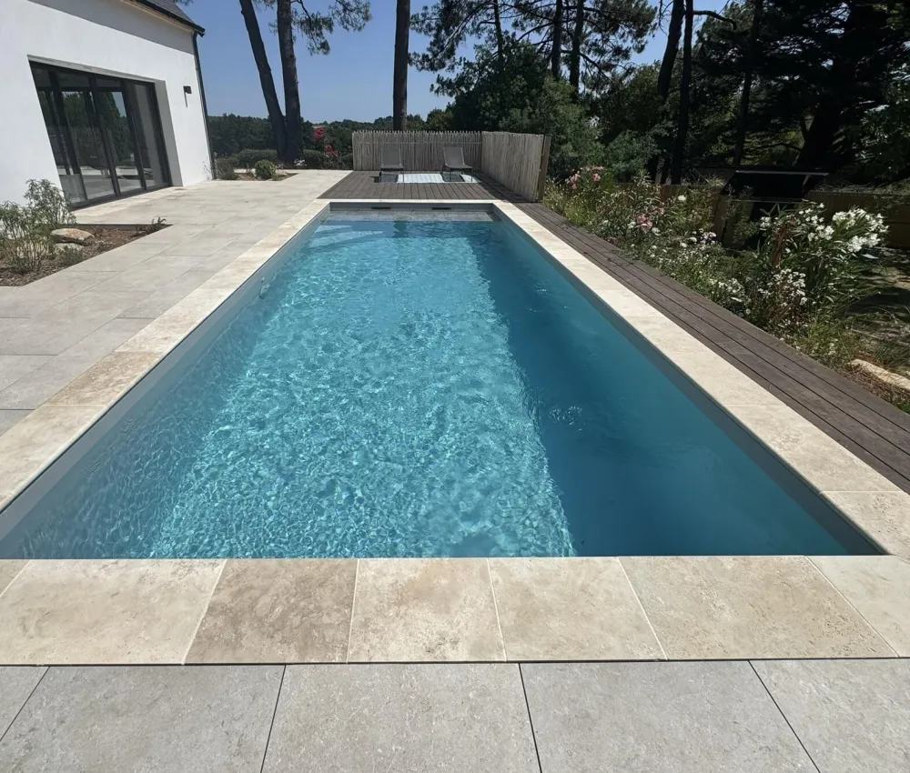 piscine rectangulaire en béton avec bord de piscine en pierre claire