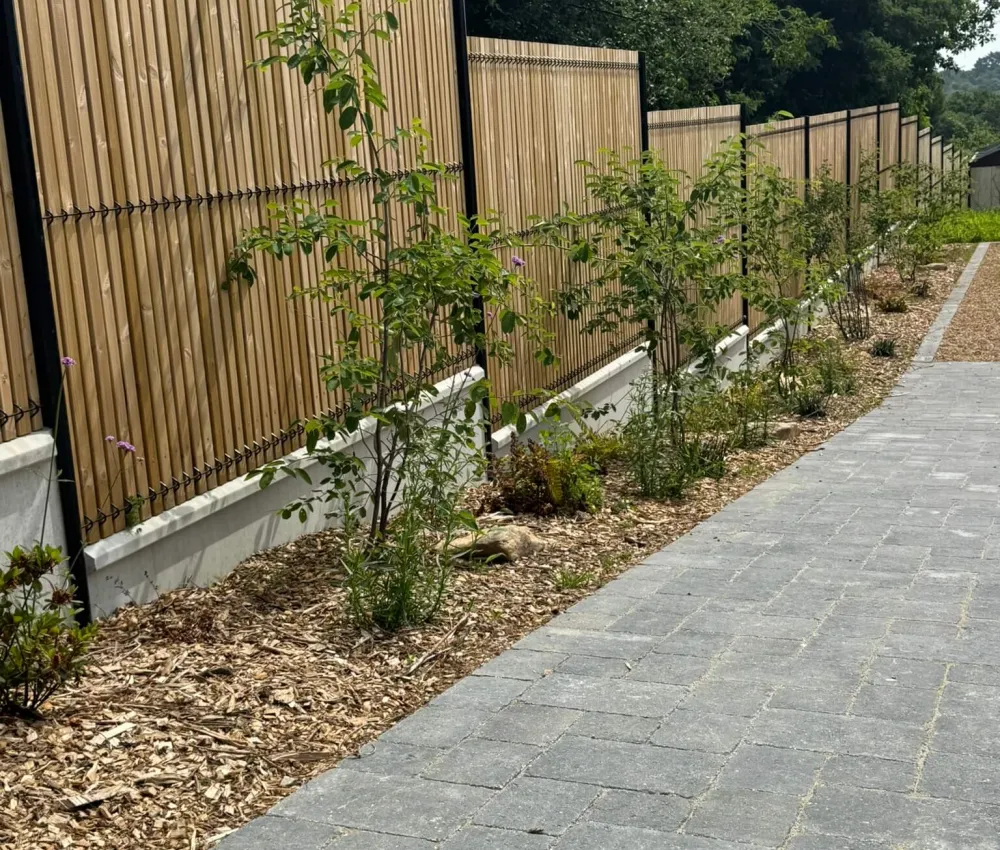 chemin pavé devant clôture en bois