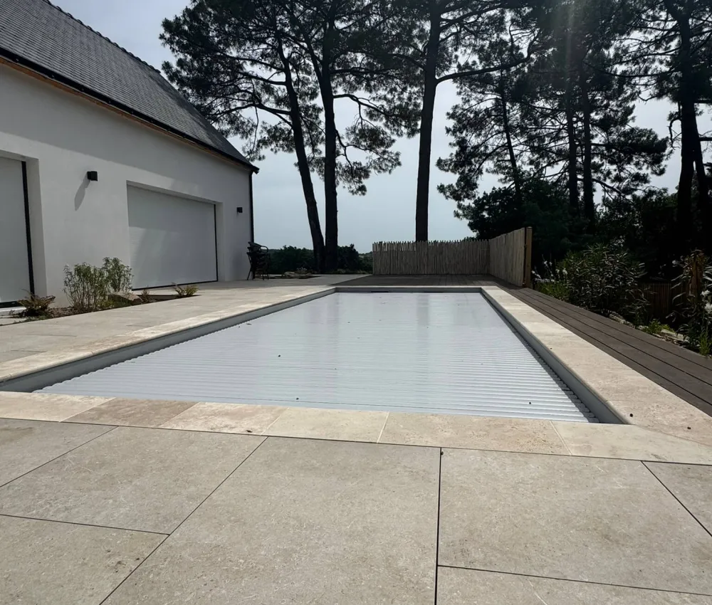 piscine couverte avec un toit de tôle ondulée et une maison moderne en arrière-plan