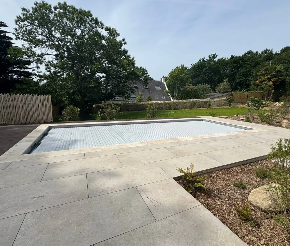 piscine rectangulaire avec couverture enroulée dans un jardin moderne