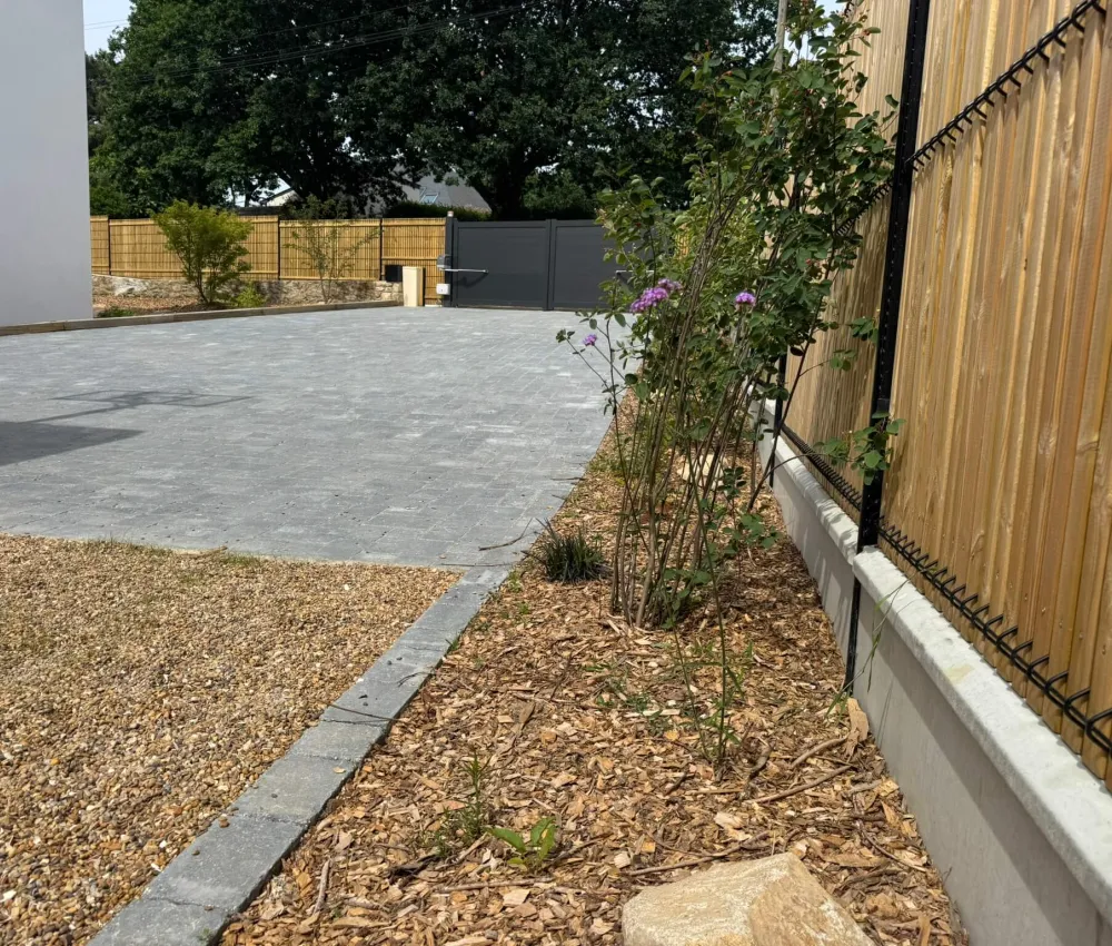 pavé en béton gris avec clôture en bois et portail de garage