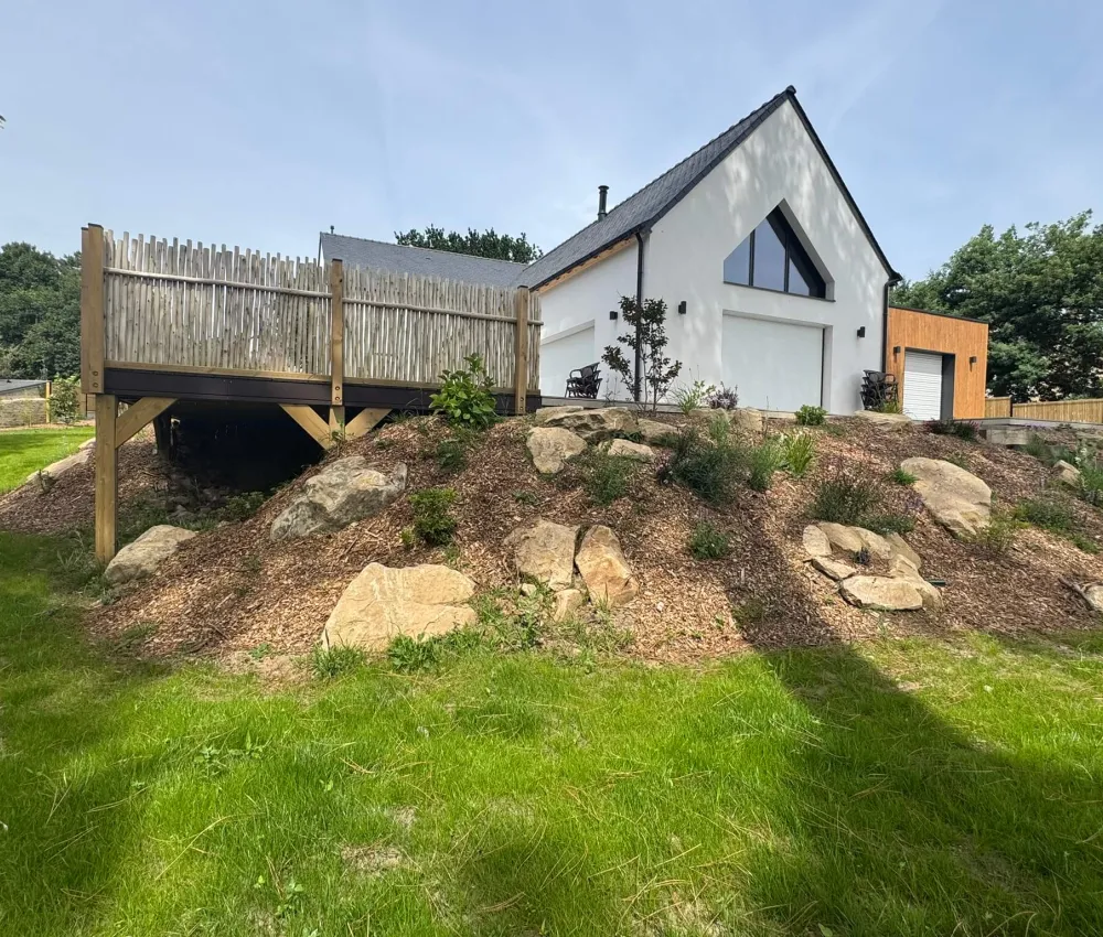 maison de paysage sur un terrain en pente avec une terrasse en bois et des rochers