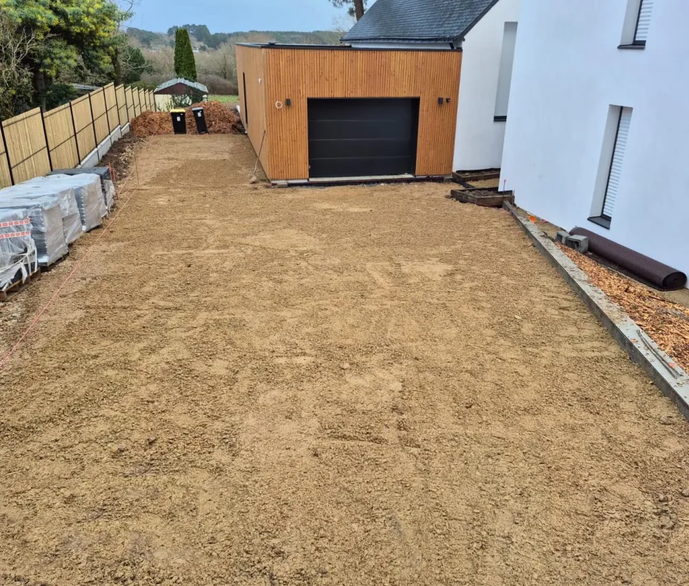 pavé en sable de terrain devant une maison et un garage